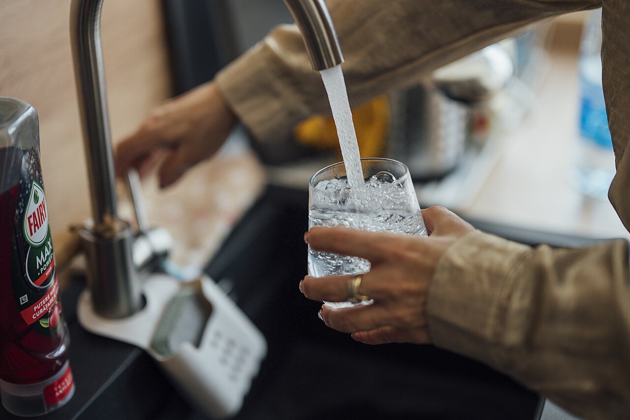 Filling a glass of water at a kitchen faucet