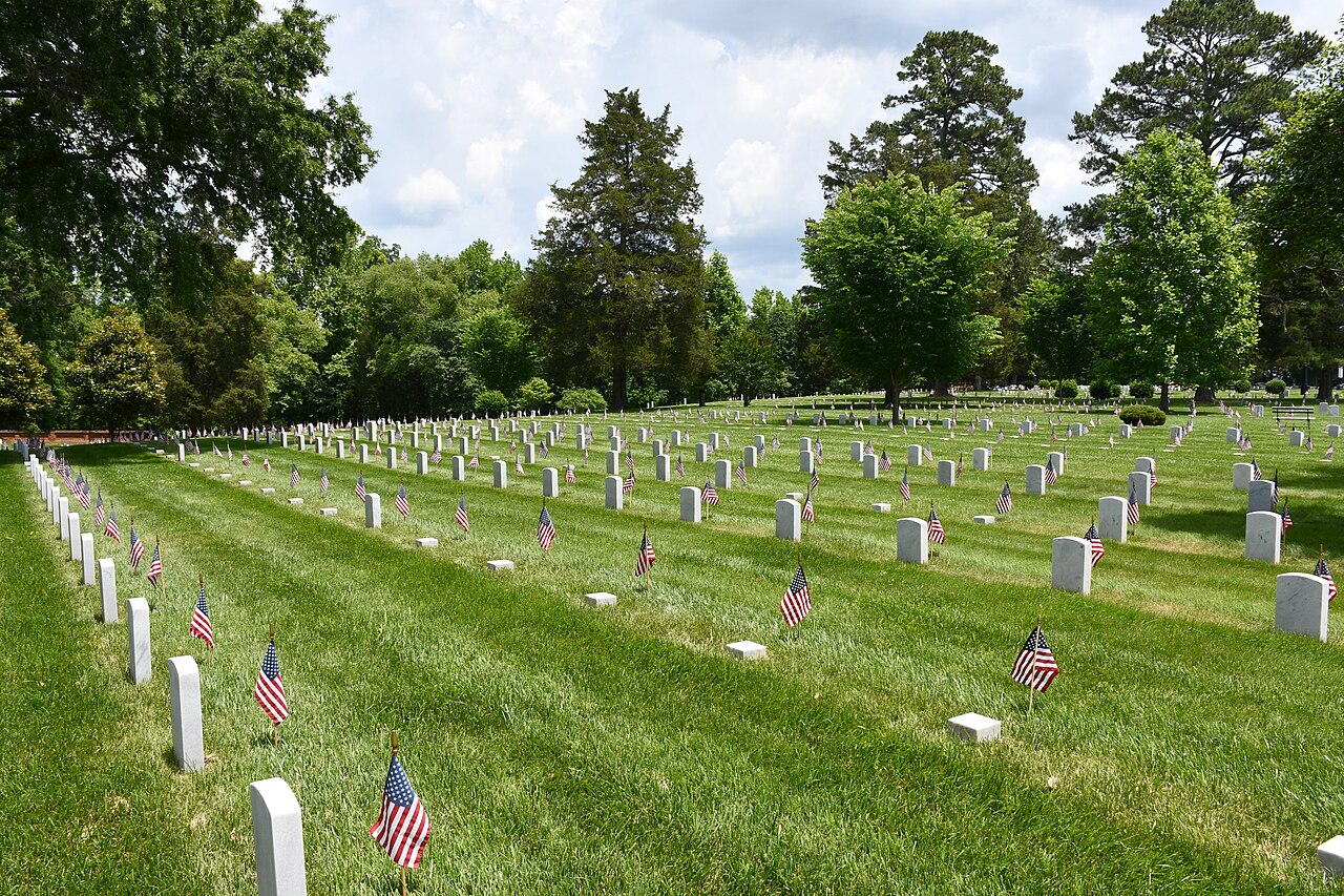 Small American flags placed at headstones in a national cemetery on Memorial Day